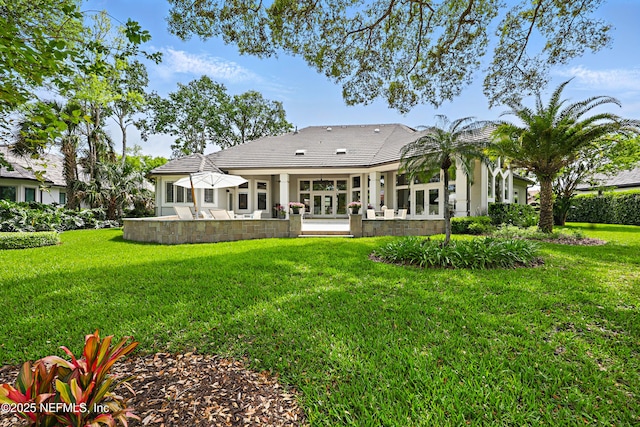back of property with a lawn and a patio