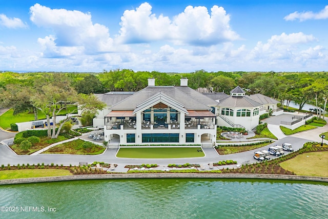 rear view of property featuring a water view and a balcony