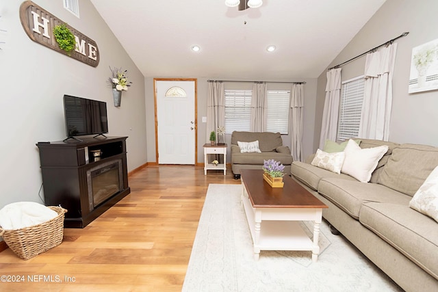 living area with visible vents, baseboards, light wood finished floors, lofted ceiling, and recessed lighting