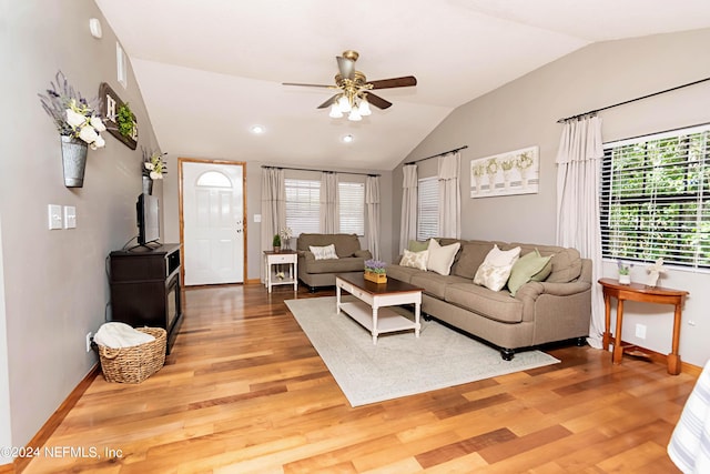 living area with baseboards, light wood finished floors, ceiling fan, and lofted ceiling