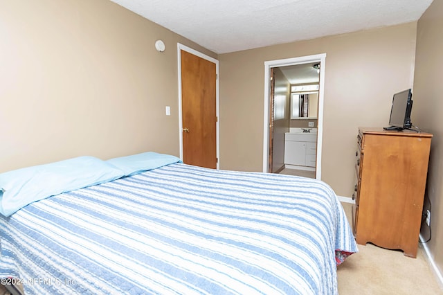bedroom with baseboards, ensuite bath, a textured ceiling, and light colored carpet