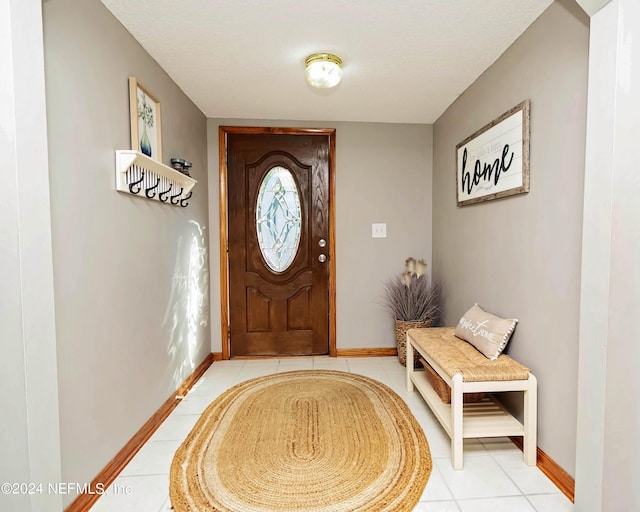 doorway to outside featuring light tile patterned floors and baseboards