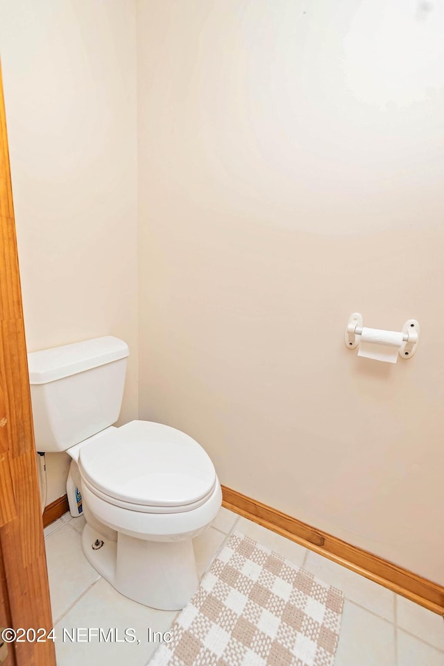 bathroom with baseboards, toilet, and tile patterned floors