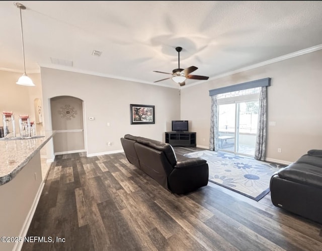 3237 Deer Creek Dr, Middleburg, FL 32068 - living room with dark wood-style flooring, a ceiling fan, ornamental molding, and arched walkways
