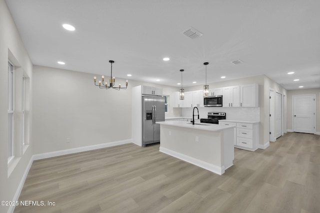 kitchen featuring a sink, appliances with stainless steel finishes, recessed lighting, and a notable chandelier