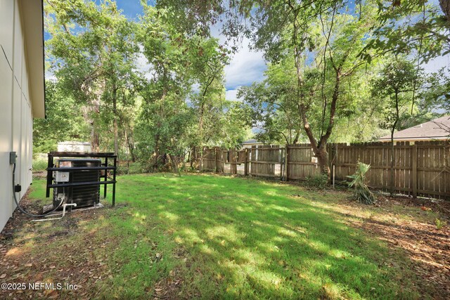 view of yard featuring central AC and a fenced backyard