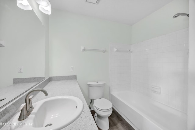 bathroom with toilet, bathtub / shower combination, wood finished floors, and vanity