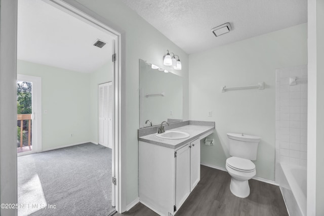 full bathroom with vanity, toilet, a textured ceiling, wood finished floors, and visible vents