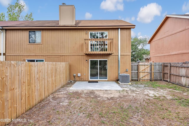 back of house featuring a chimney, roof with shingles, central AC unit, a fenced backyard, and a patio