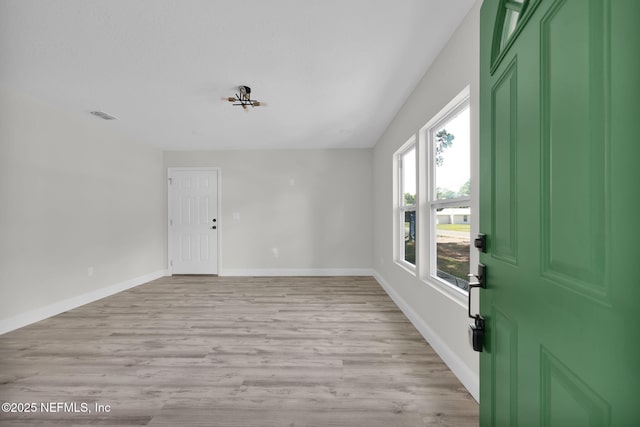 interior space with baseboards, visible vents, and light wood-style flooring