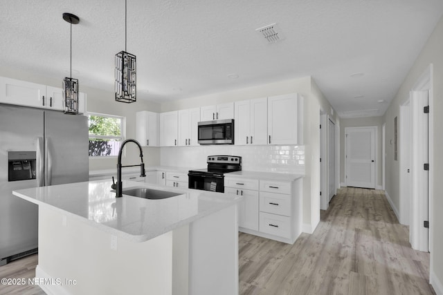 kitchen with light wood-style floors, a sink, white cabinetry, and appliances with stainless steel finishes