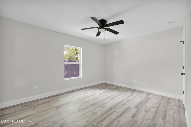 spare room featuring baseboards and wood finished floors