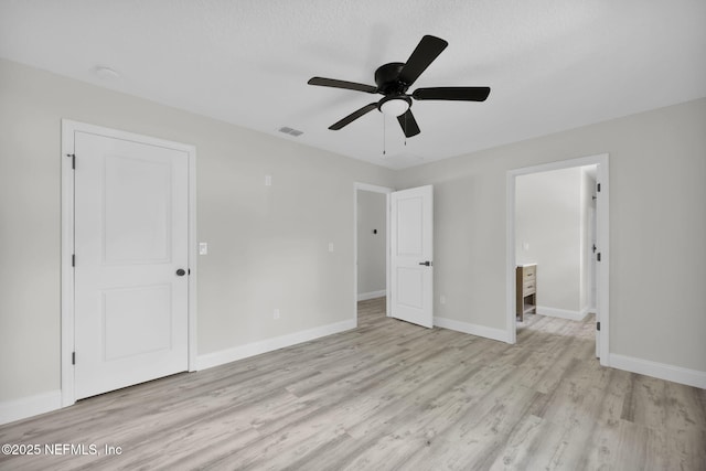 unfurnished bedroom featuring light wood-style floors, baseboards, ceiling fan, and visible vents