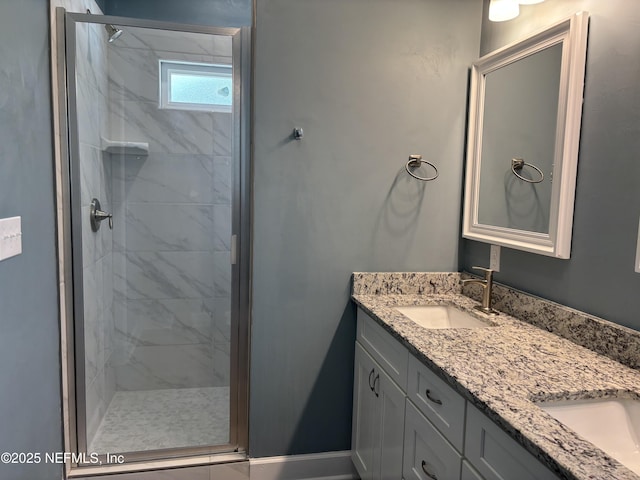 bathroom featuring double vanity, a sink, and a stall shower