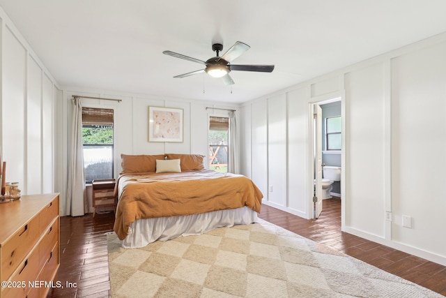 12548 Dunraven Trl, Jacksonville, FL 32223 - bedroom with a decorative wall, multiple windows, dark wood-type flooring, ceiling fan, and connected bathroom