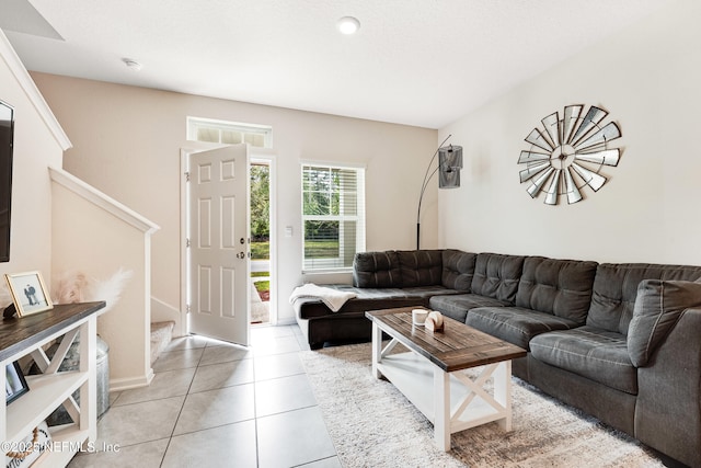 living room featuring light tile patterned flooring and stairway