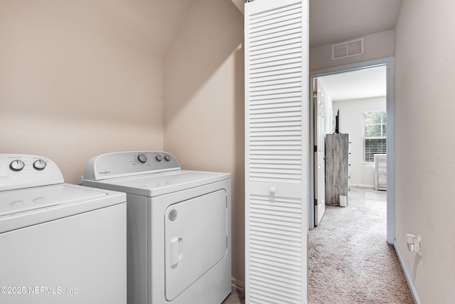 laundry area featuring laundry area, visible vents, light colored carpet, baseboards, and washer and dryer