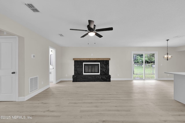 unfurnished living room with visible vents, light wood-style flooring, and ceiling fan with notable chandelier