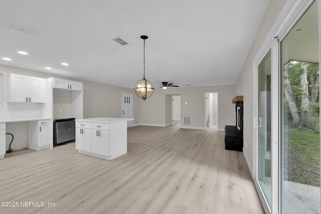 kitchen with light wood-style floors, white cabinets, and visible vents