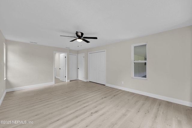 spare room featuring baseboards, a ceiling fan, visible vents, and light wood-type flooring