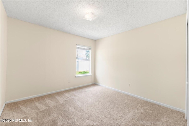 carpeted spare room with baseboards and a textured ceiling