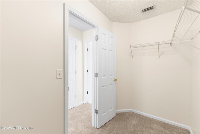 spacious closet with light carpet and visible vents