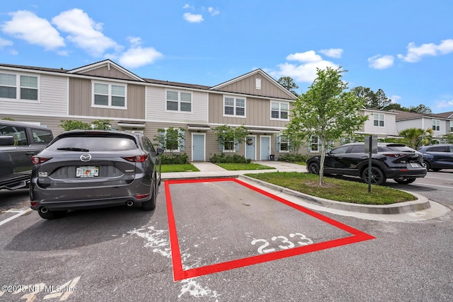 townhome / multi-family property with board and batten siding and uncovered parking