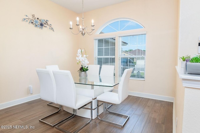 dining area featuring an inviting chandelier, baseboards, and wood finished floors