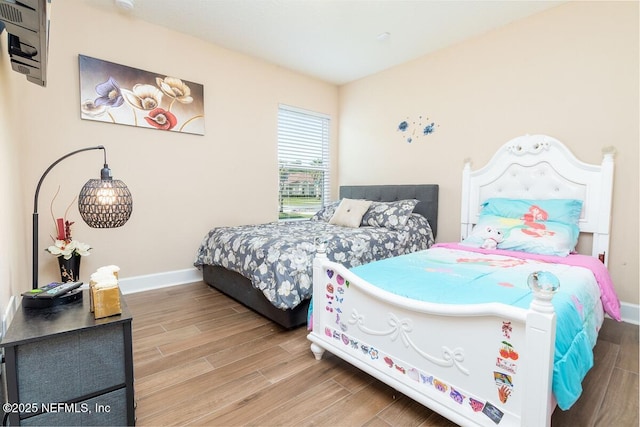 bedroom with baseboards and wood finished floors