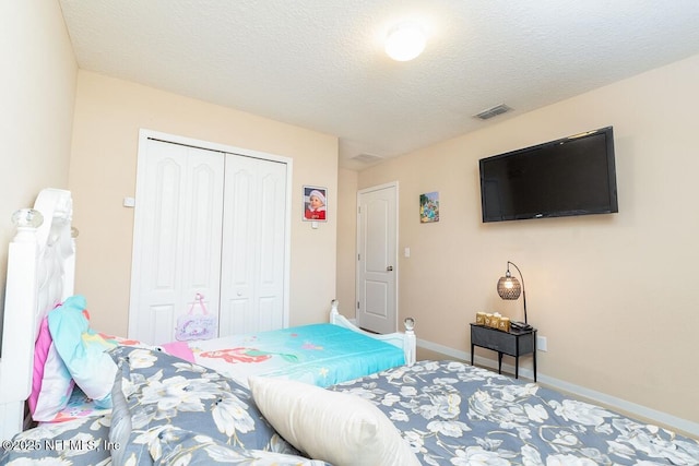 carpeted bedroom featuring a textured ceiling, baseboards, visible vents, and a closet