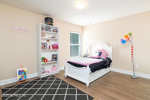 bedroom featuring baseboards and wood finished floors