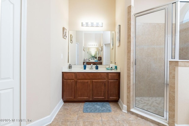 bathroom with vanity, baseboards, a stall shower, and tile patterned floors