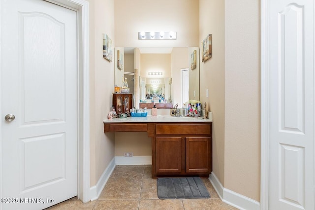 bathroom with baseboards, tile patterned flooring, and vanity