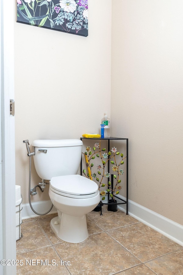 bathroom with baseboards and toilet