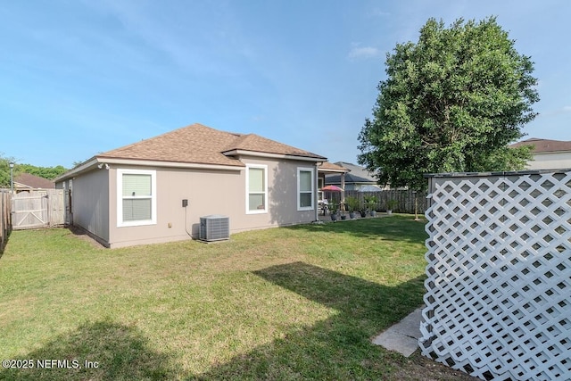 back of property featuring a lawn, a gate, a fenced backyard, and central air condition unit