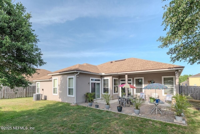 back of property featuring a patio area, central AC, fence, a yard, and stucco siding