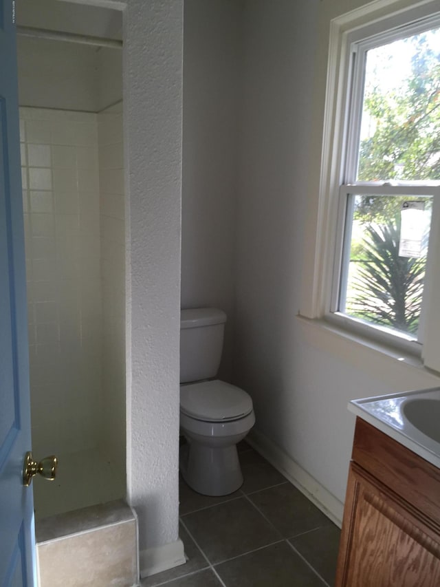 full bathroom featuring vanity, walk in shower, tile patterned floors, and toilet