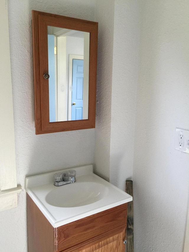 bathroom with vanity and a textured wall