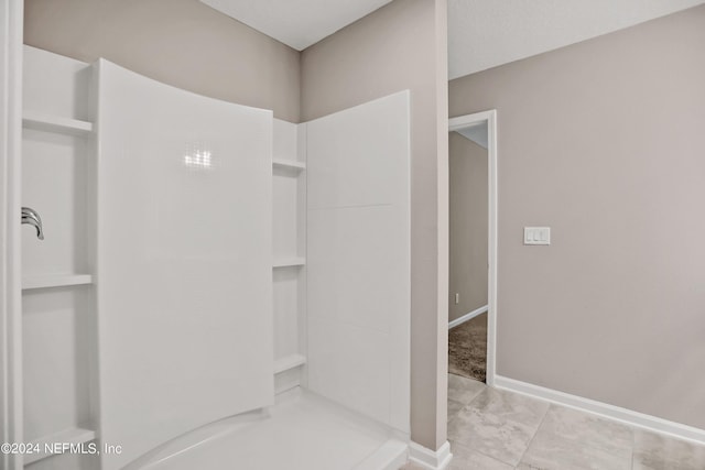bathroom featuring baseboards, marble finish floor, and a shower