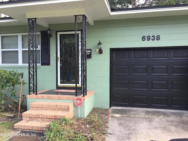 property entrance with a garage and concrete block siding
