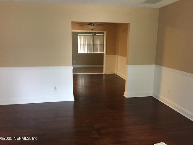 spare room with a ceiling fan and dark wood-type flooring