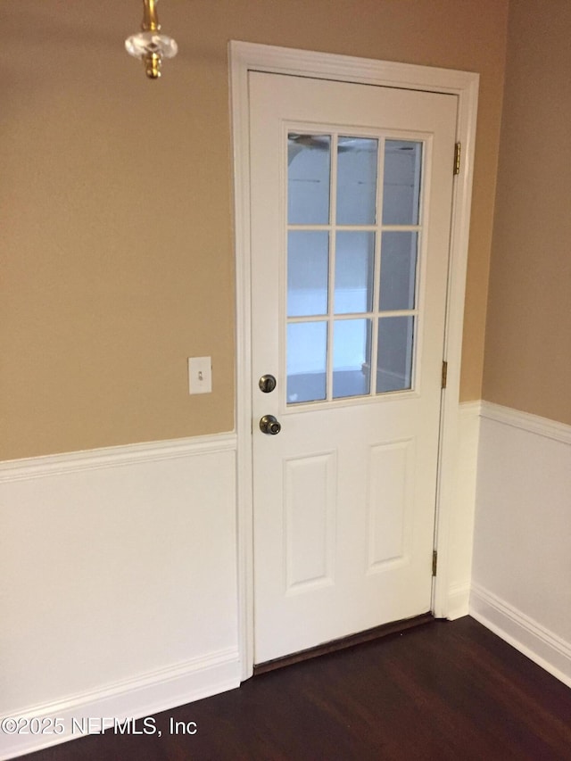 doorway with baseboards and dark wood-style floors