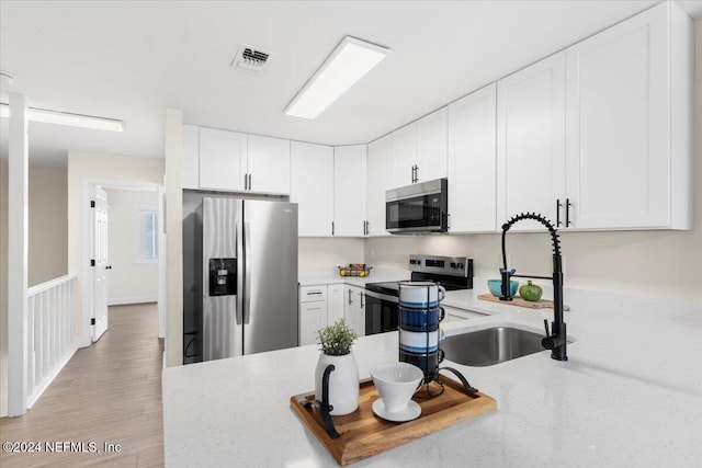 3385 Coastal Hwy Unit 23, Saint Augustine, FL 32084 - kitchen with visible vents, a sink, white cabinetry, and appliances with stainless steel finishes