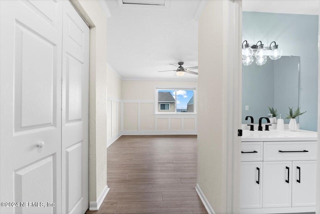 3385 Coastal Hwy Unit 23, Saint Augustine, FL 32084 - corridor featuring a sink, baseboards, ornamental molding, and wood finished floors