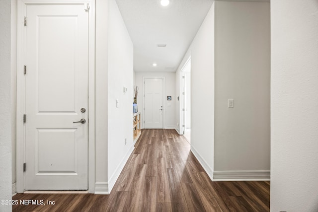 hallway with recessed lighting, baseboards, and dark wood-style flooring