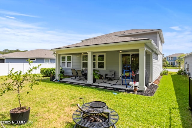 back of house featuring a patio, a fire pit, fence, and a yard