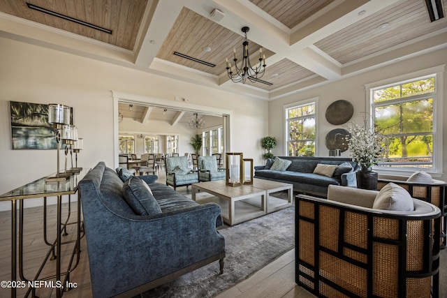 living room with a healthy amount of sunlight, hardwood / wood-style floors, beamed ceiling, wood ceiling, and a chandelier