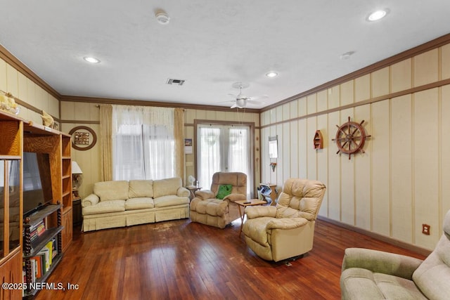 living room with ceiling fan, visible vents, hardwood / wood-style flooring, ornamental molding, and recessed lighting