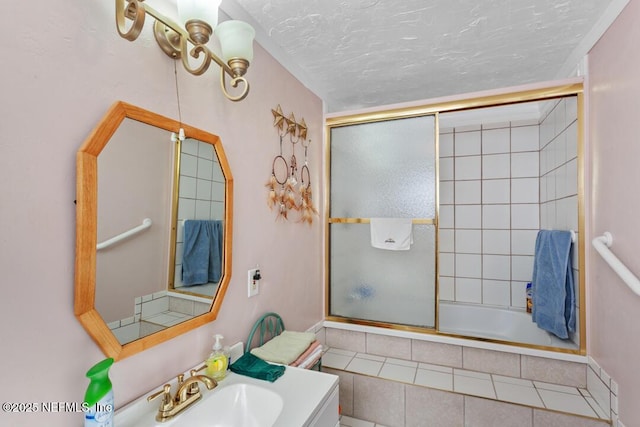 bathroom featuring a textured ceiling, tiled shower / bath, and vanity