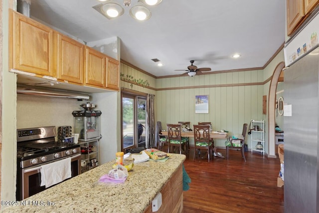 kitchen with dark wood-style flooring, appliances with stainless steel finishes, under cabinet range hood, visible vents, and ornamental molding